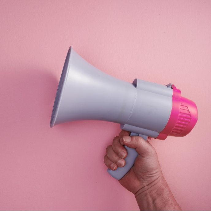 A hand holding a pink megaphone symbolizing digital marketing for printables.
